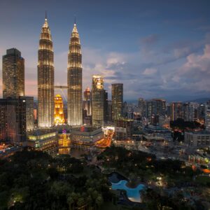 Stunning Kuala Lumpur skyline featuring the illuminated Petronas Towers at twilight.